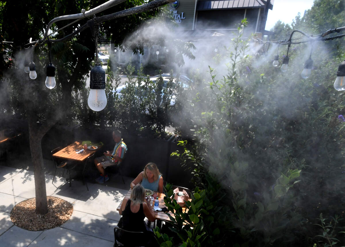 Diners at Heirloom enjoy lunch under swirling water vapors provided by misters in the restaurant’s patio in this file photo from 2020.